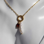 Stylish gold plated stainless steel necklace featuring freshwater pearl and charms